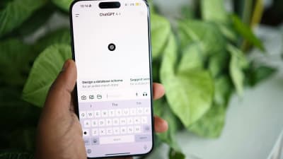 Hand hält ein Smartphone mit geöffneter ChatGPT-App, im Hintergrund grüne Pflanzen